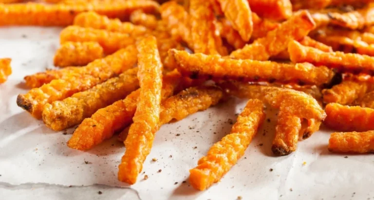Crispy golden fries garnished with parsley, lime wedges, and red chili slices